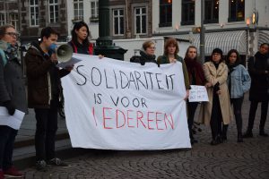 [Group of people holding a banner with the slogan "Solidariteit is voor iedereen"]